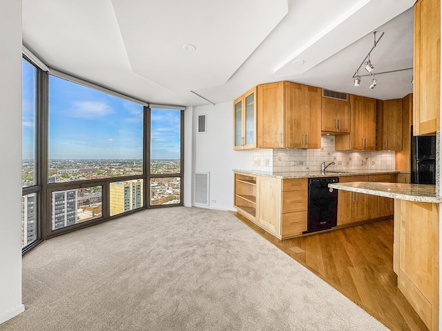 kitchen featuring dishwasher, a wall of windows, backsplash, glass insert cabinets, and carpet