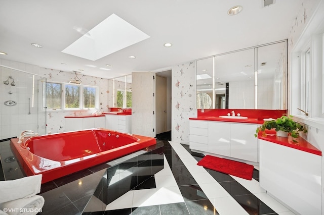bathroom featuring vanity, recessed lighting, a shower stall, a skylight, and a bath