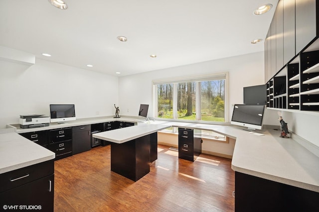 unfurnished office featuring built in study area, recessed lighting, and wood finished floors