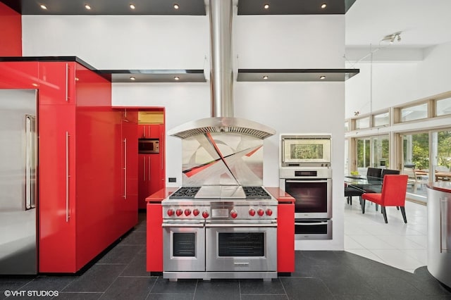 kitchen with red cabinetry, a high ceiling, high quality appliances, recessed lighting, and a warming drawer