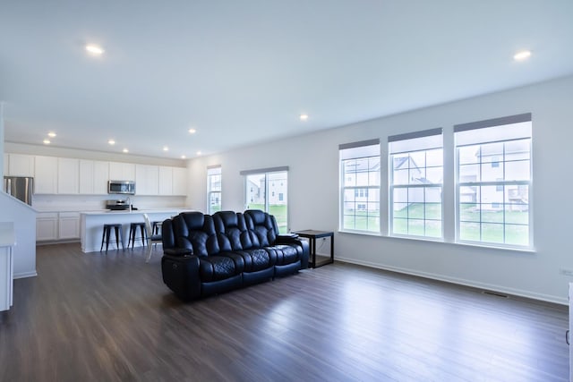 living area featuring dark wood finished floors, baseboards, visible vents, and recessed lighting