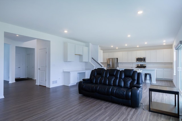 living area featuring dark wood-type flooring, visible vents, and recessed lighting