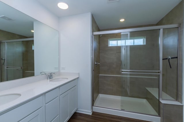 full bathroom with visible vents, a sink, double vanity, and a stall shower