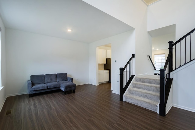 living area featuring baseboards, stairs, dark wood-style floors, and visible vents