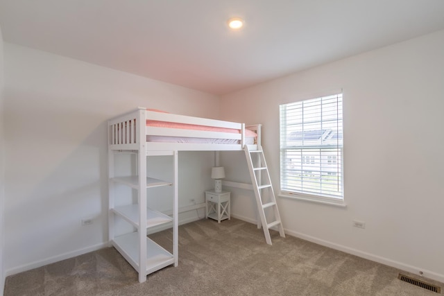 carpeted bedroom featuring visible vents and baseboards