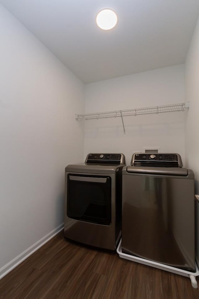 laundry area featuring baseboards, washer and dryer, dark wood-style flooring, and laundry area