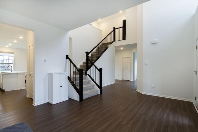 interior space featuring dark wood-type flooring, stairs, baseboards, and recessed lighting