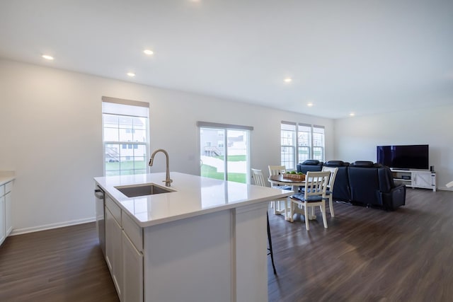 kitchen featuring white cabinets, light countertops, a sink, and dark wood-type flooring