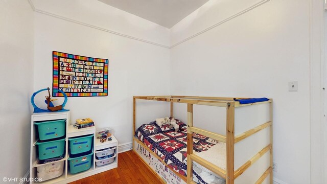 bedroom with baseboards and wood finished floors