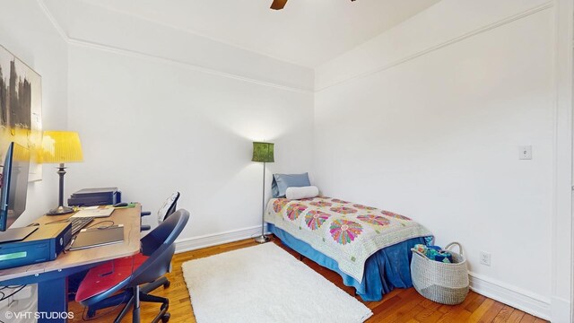 bedroom featuring wood finished floors, a ceiling fan, and baseboards