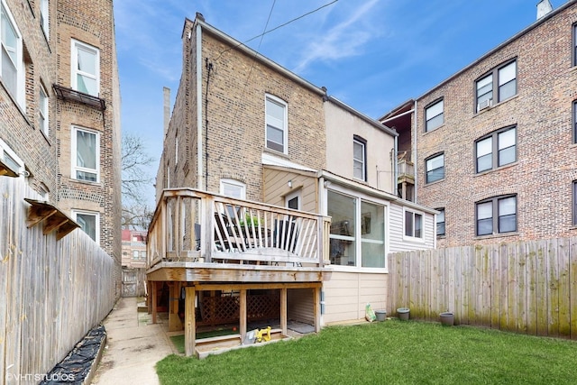back of property featuring a wooden deck, a fenced backyard, and a yard