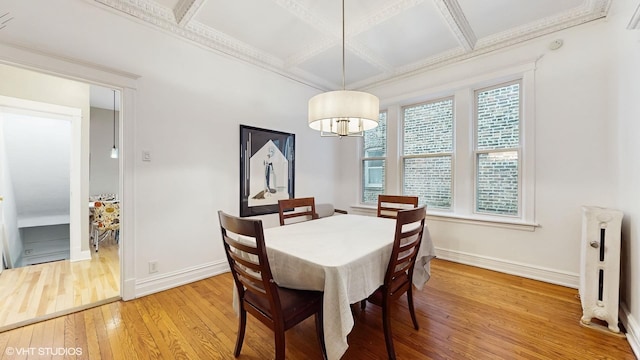 dining room with ornamental molding, light wood-style flooring, baseboards, and coffered ceiling