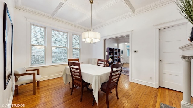 dining area with coffered ceiling, crown molding, baseboards, light wood-style flooring, and a notable chandelier