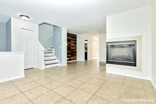 131 W Big Horn Dr Unit 131, Hainesville, IL 60030 - unfurnished living room featuring stairway, a tiled fireplace, baseboards, and light tile patterned floors