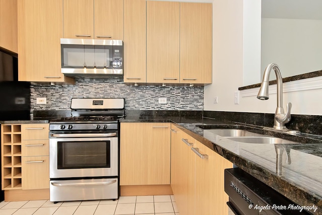 131 W Big Horn Dr Unit 131, Hainesville, IL 60030 - kitchen with light brown cabinetry, stainless steel appliances, light tile patterned floors, a sink, and dark stone counters