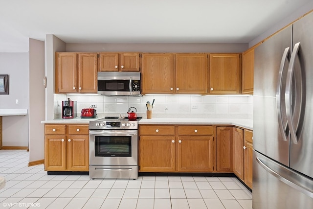 kitchen featuring light countertops, appliances with stainless steel finishes, and tasteful backsplash