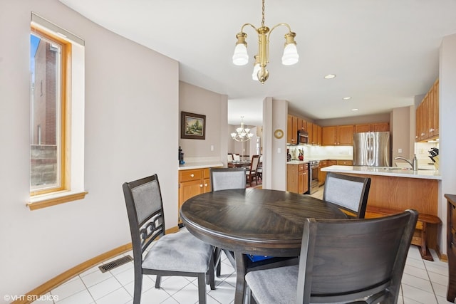 dining room featuring light tile patterned flooring, baseboards, an inviting chandelier, and visible vents
