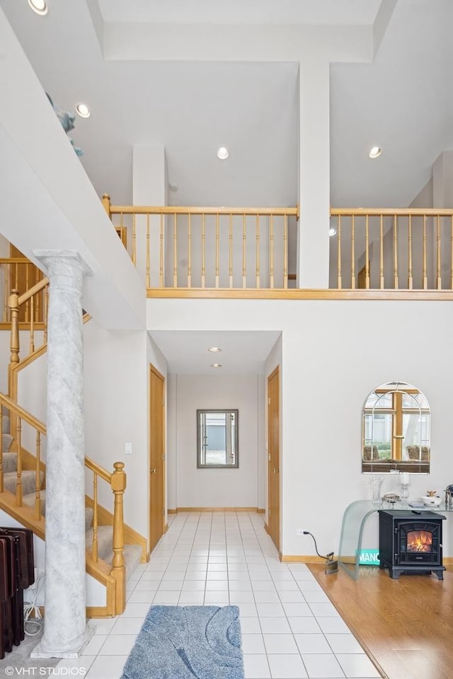 foyer featuring stairway, plenty of natural light, recessed lighting, and a towering ceiling