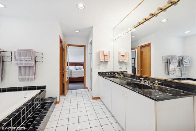 ensuite bathroom with a sink, a garden tub, recessed lighting, and connected bathroom