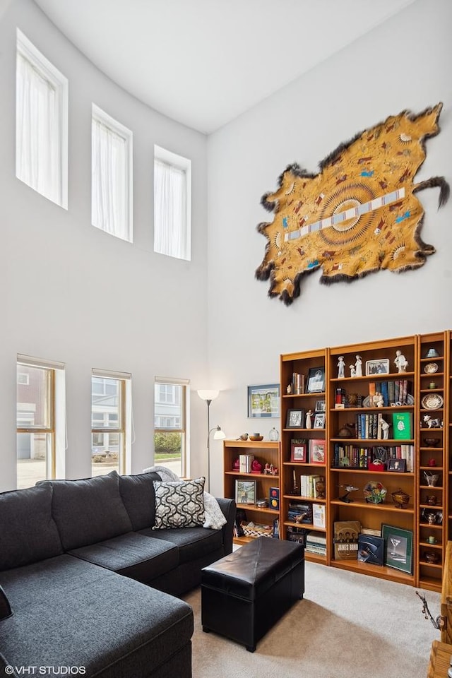 carpeted living room with plenty of natural light and a towering ceiling