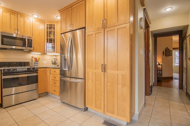 kitchen with visible vents, light tile patterned flooring, decorative backsplash, glass insert cabinets, and appliances with stainless steel finishes