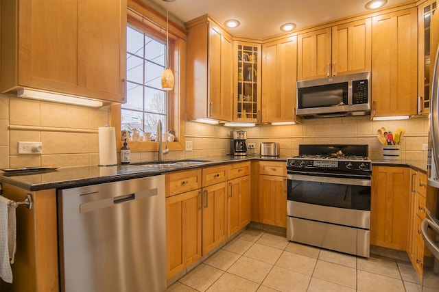 kitchen with tasteful backsplash, appliances with stainless steel finishes, and a sink