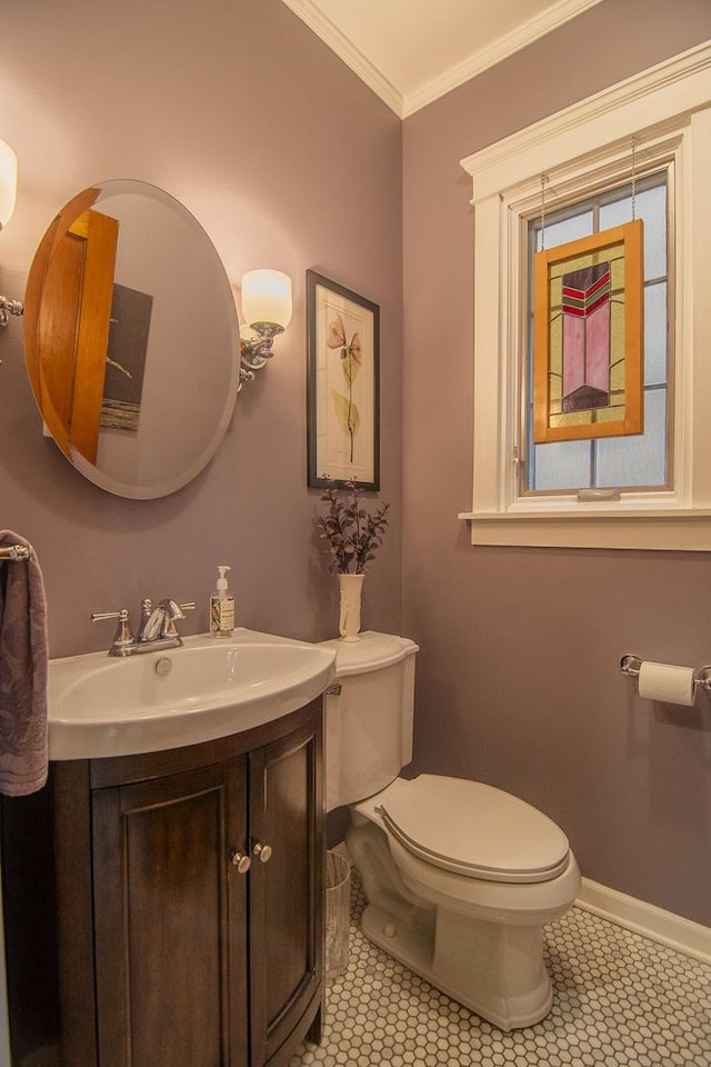half bath with tile patterned flooring, toilet, vanity, and ornamental molding