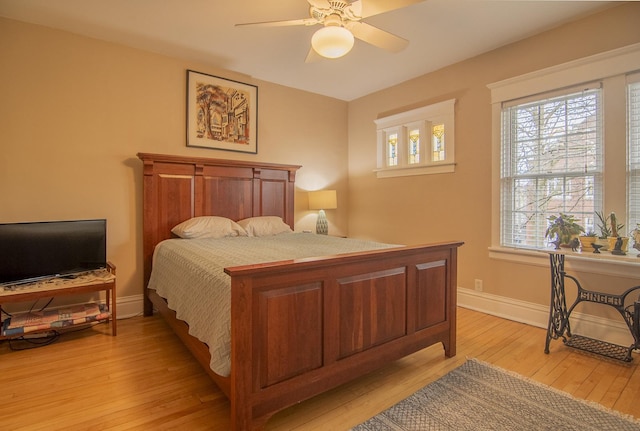 bedroom featuring light wood-type flooring, a ceiling fan, and baseboards
