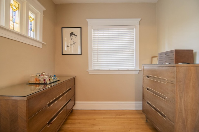 bedroom featuring light wood finished floors and baseboards