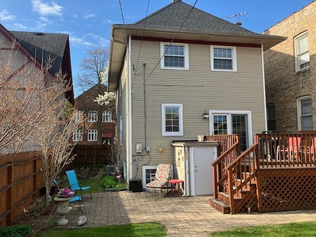 rear view of property featuring fence, a shingled roof, stairway, a deck, and a patio