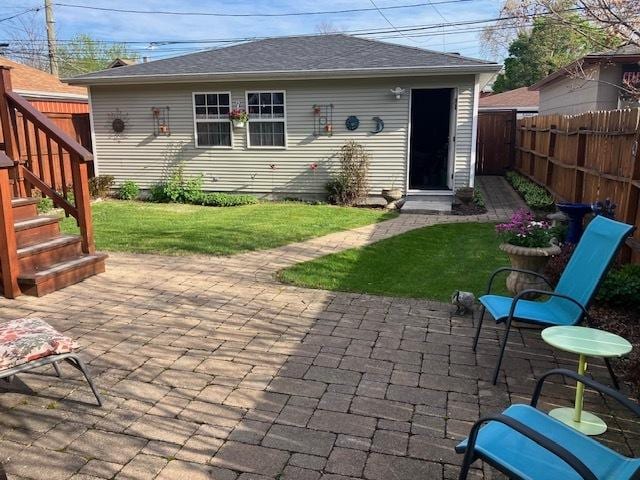 back of house featuring a fenced backyard, a yard, and a patio area