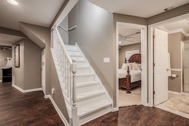stairs with wood finished floors, baseboards, and ceiling fan