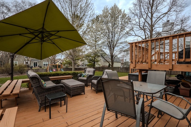 wooden terrace with a fenced backyard, outdoor lounge area, outdoor dining space, and a playground