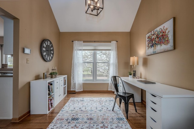 office featuring vaulted ceiling, wood finished floors, a chandelier, and baseboards