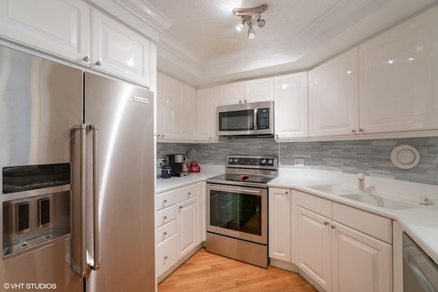 kitchen with appliances with stainless steel finishes, tasteful backsplash, crown molding, and a sink