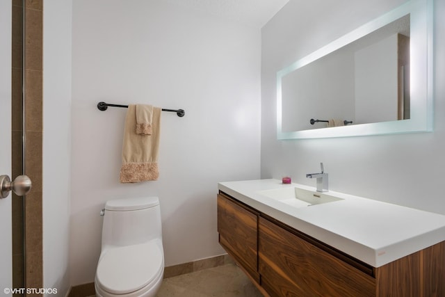 bathroom with baseboards, toilet, vanity, and tile patterned floors