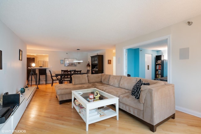 living area with light wood-style flooring and baseboards