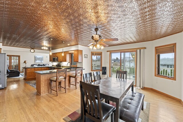 dining room with plenty of natural light, an ornate ceiling, and light wood-style flooring