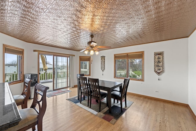 dining room with an ornate ceiling, light wood finished floors, baseboards, and a ceiling fan