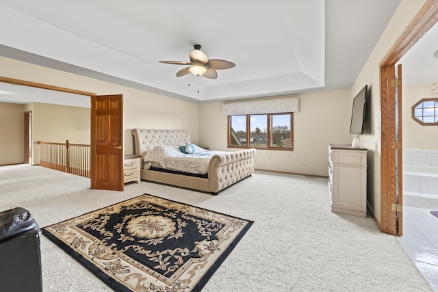 bedroom with a tray ceiling, baseboards, light colored carpet, and multiple windows