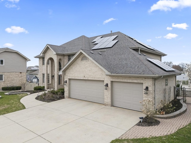 french country style house with concrete driveway, fence, brick siding, an attached garage, and a shingled roof