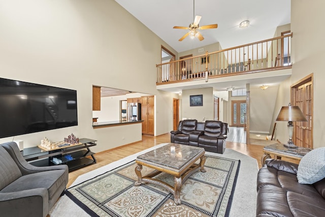 living area with light wood finished floors, high vaulted ceiling, and ceiling fan