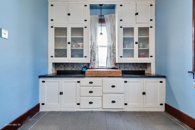 2021 1st St, Peru, IL 61354 - kitchen with glass insert cabinets, white cabinetry, decorative backsplash, and baseboards