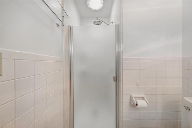 full bathroom with wainscoting, tile walls, a shower stall, and toilet