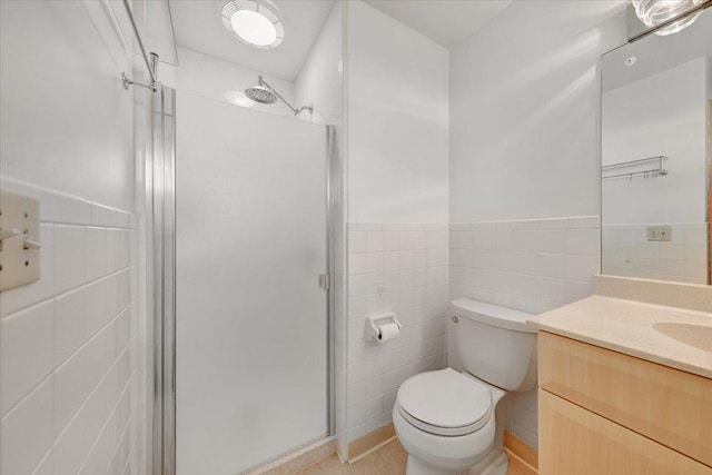 full bath featuring vanity, toilet, a wainscoted wall, tile walls, and a shower stall