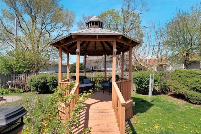 deck featuring fence, a gazebo, and a lawn