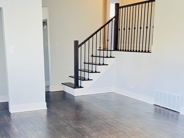 staircase with baseboards, wood finished floors, and visible vents