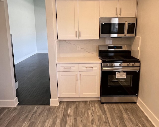 kitchen featuring light countertops, stainless steel appliances, baseboards, white cabinetry, and wood finished floors