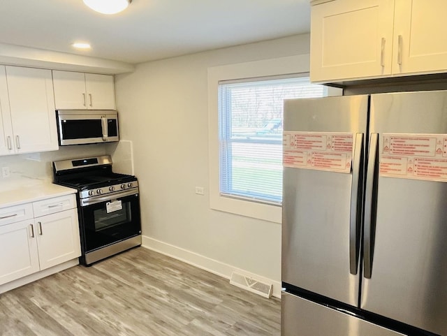 kitchen featuring visible vents, light wood-style flooring, white cabinetry, and stainless steel appliances