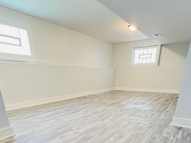 basement featuring baseboards, wood finished floors, and visible vents